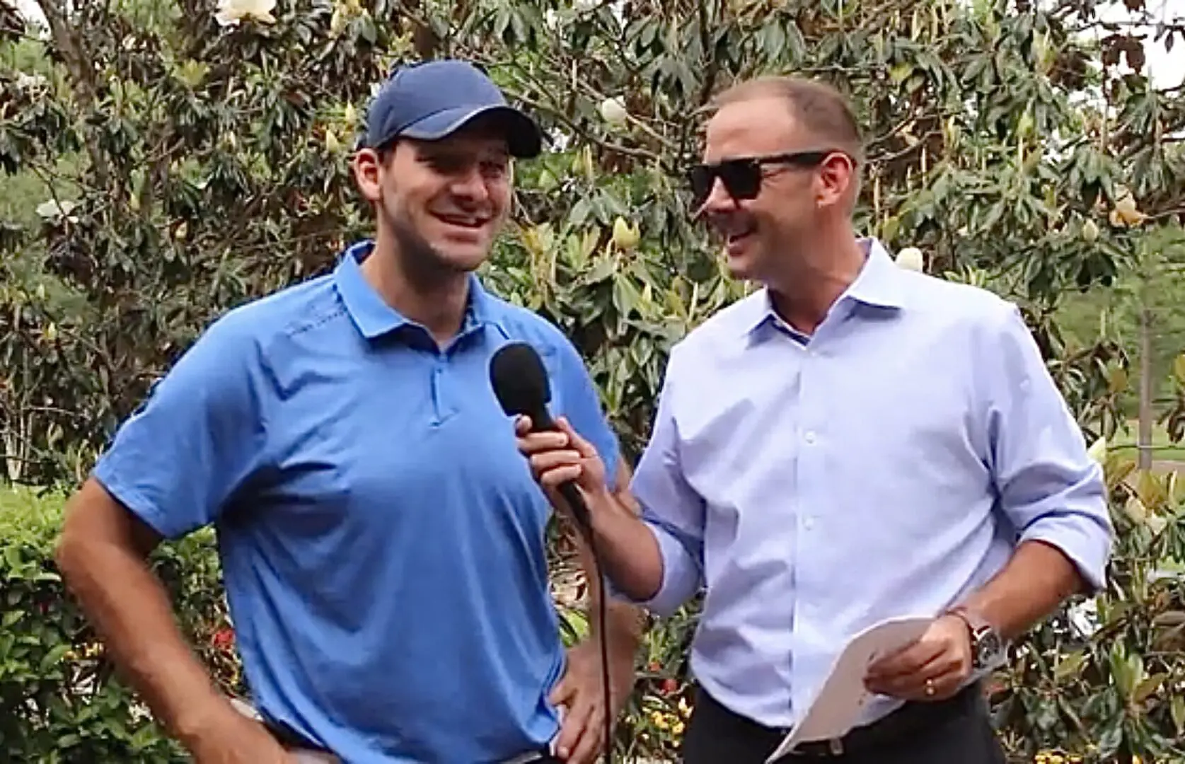 Two men are talking to each other while holding microphones.