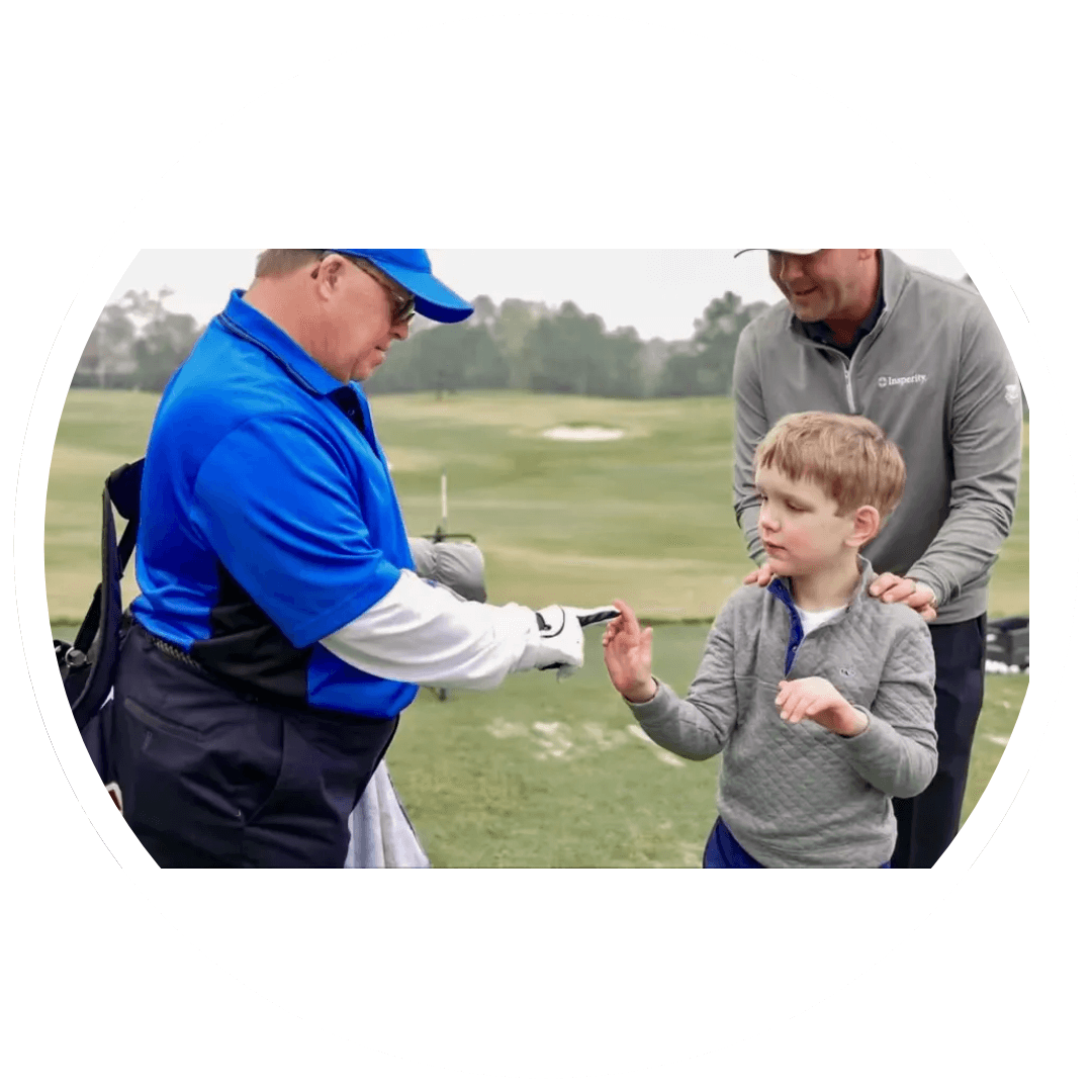 A man giving a boy a high five on the golf course.